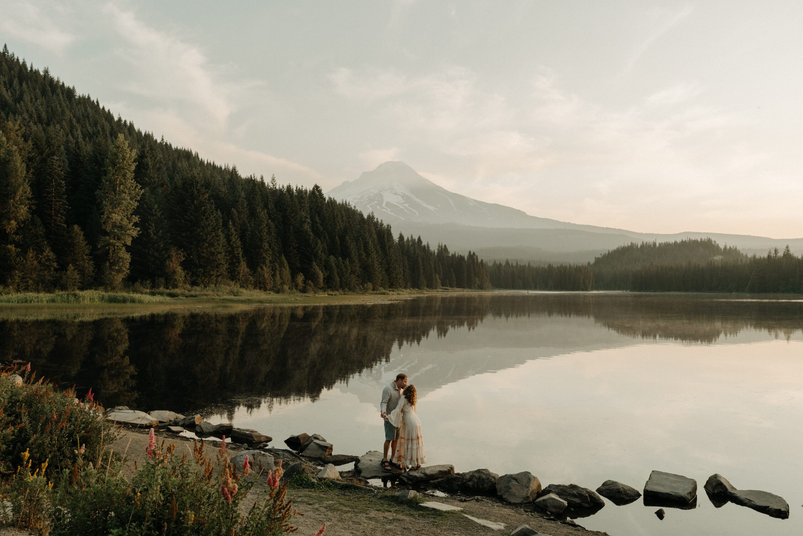 Couple posing during sunrise at Trillium Lake with Mount Hood in the background